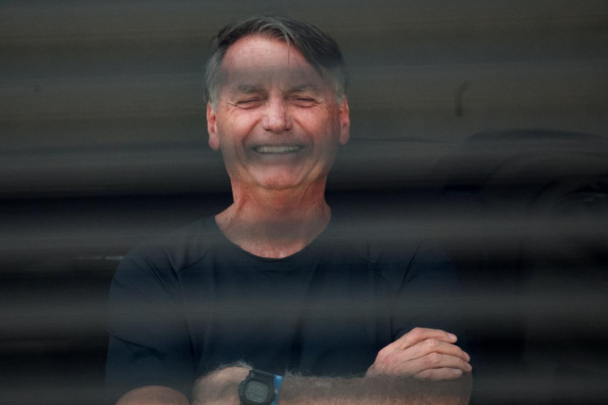 El expresidente de Brasil, Jair Bolsonaro, saluda a sus afines desde su casa de Brasilia, donde sigue en arresto domiciliario, el 14 de agosto de 2025.