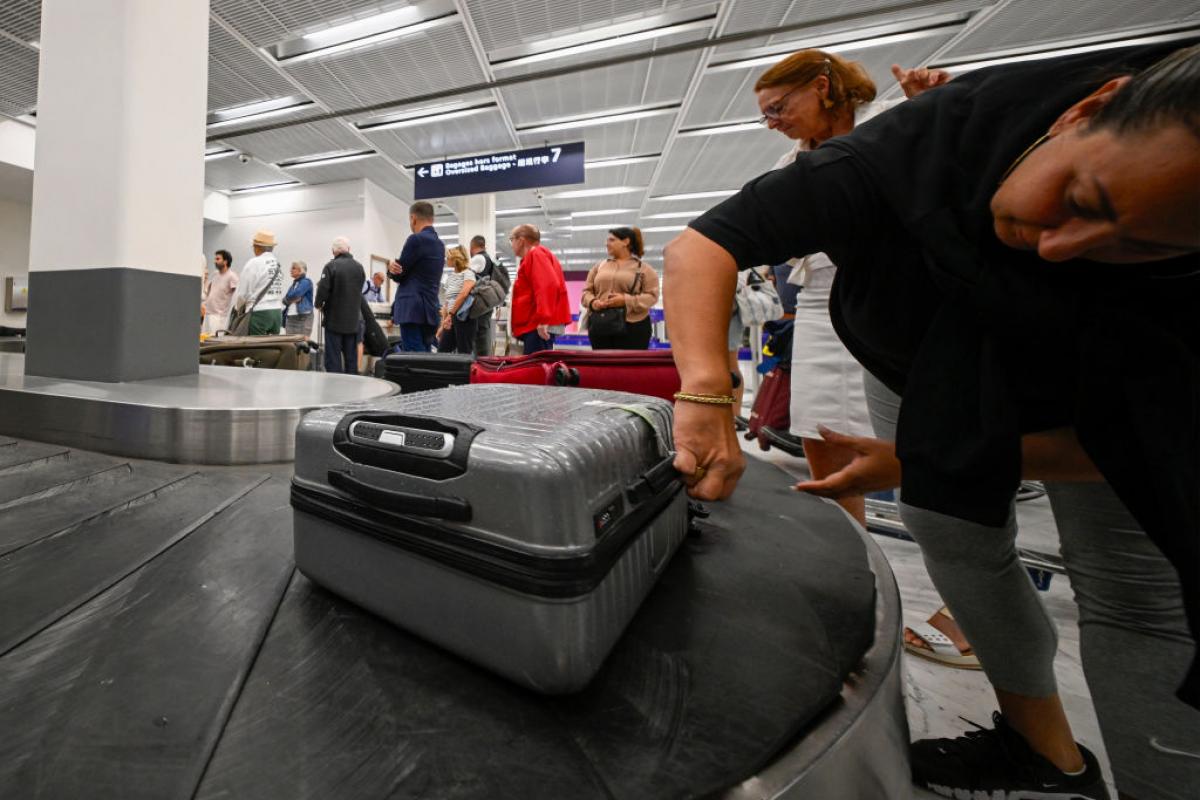 Pasajeros recogiendo sus maletas en la cinta de equipajes de un aeropuerto: las negras y grises, las favoritas para perderse… o para que otro se las lleve.
