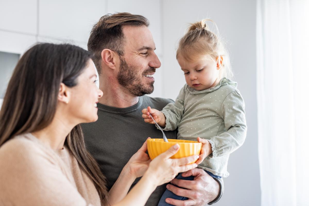 Una pareja con su hija pequeña en brazos antes de darle de comer
