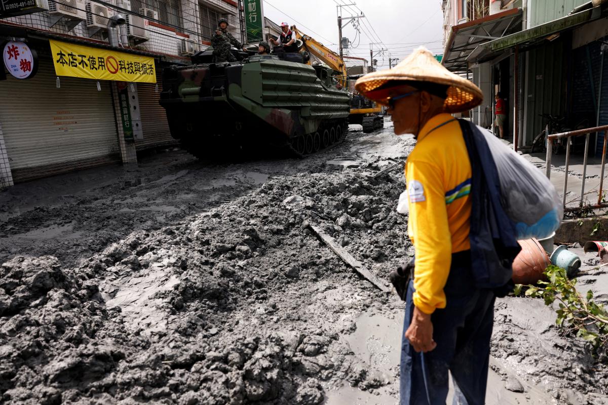 Un hombre junto a un vehículo blindado militar, en una calle de Hualien (Taiwán), tras el impacto del supertifón Ragasa.