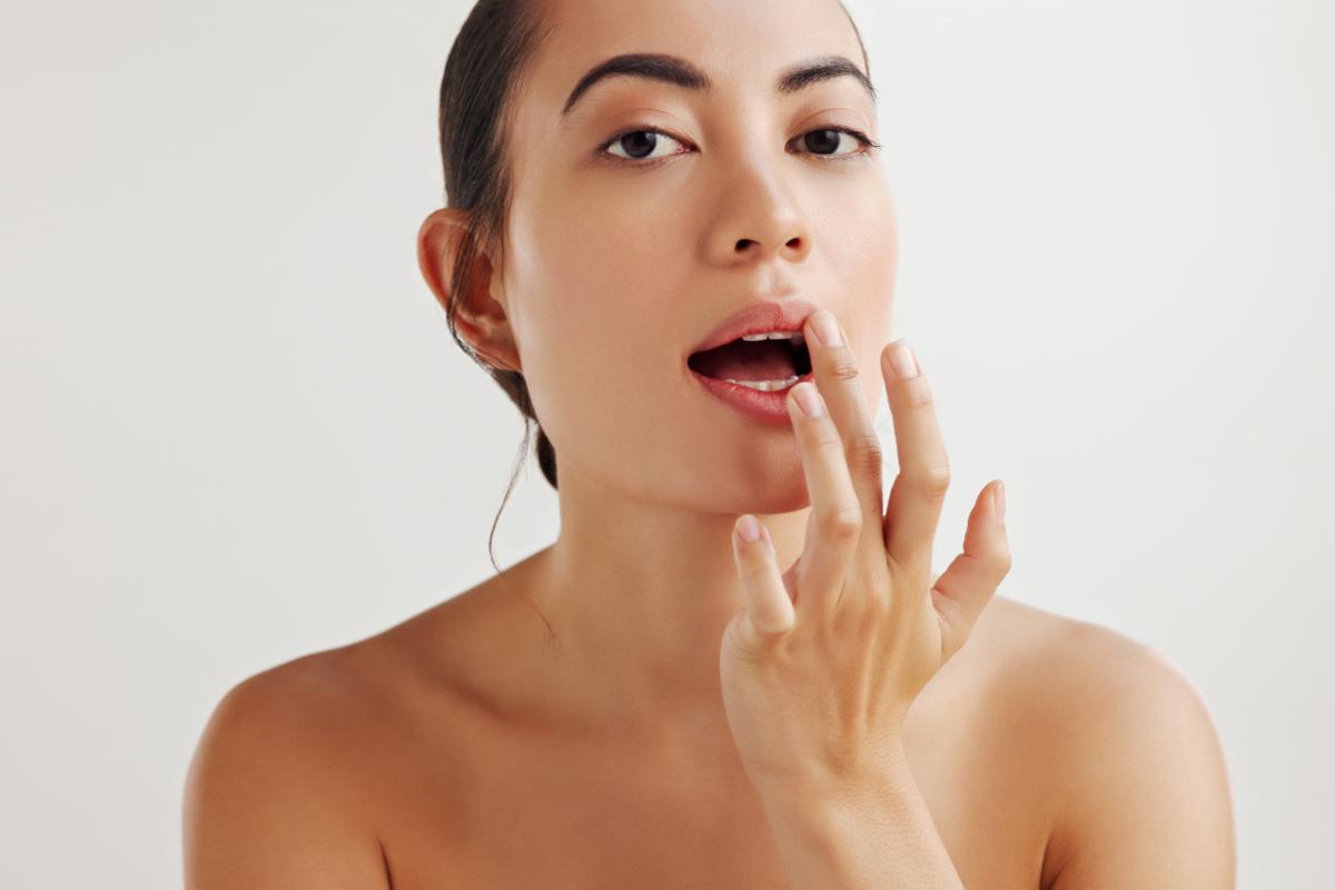 Mujer aplicándose bálsamo labial.