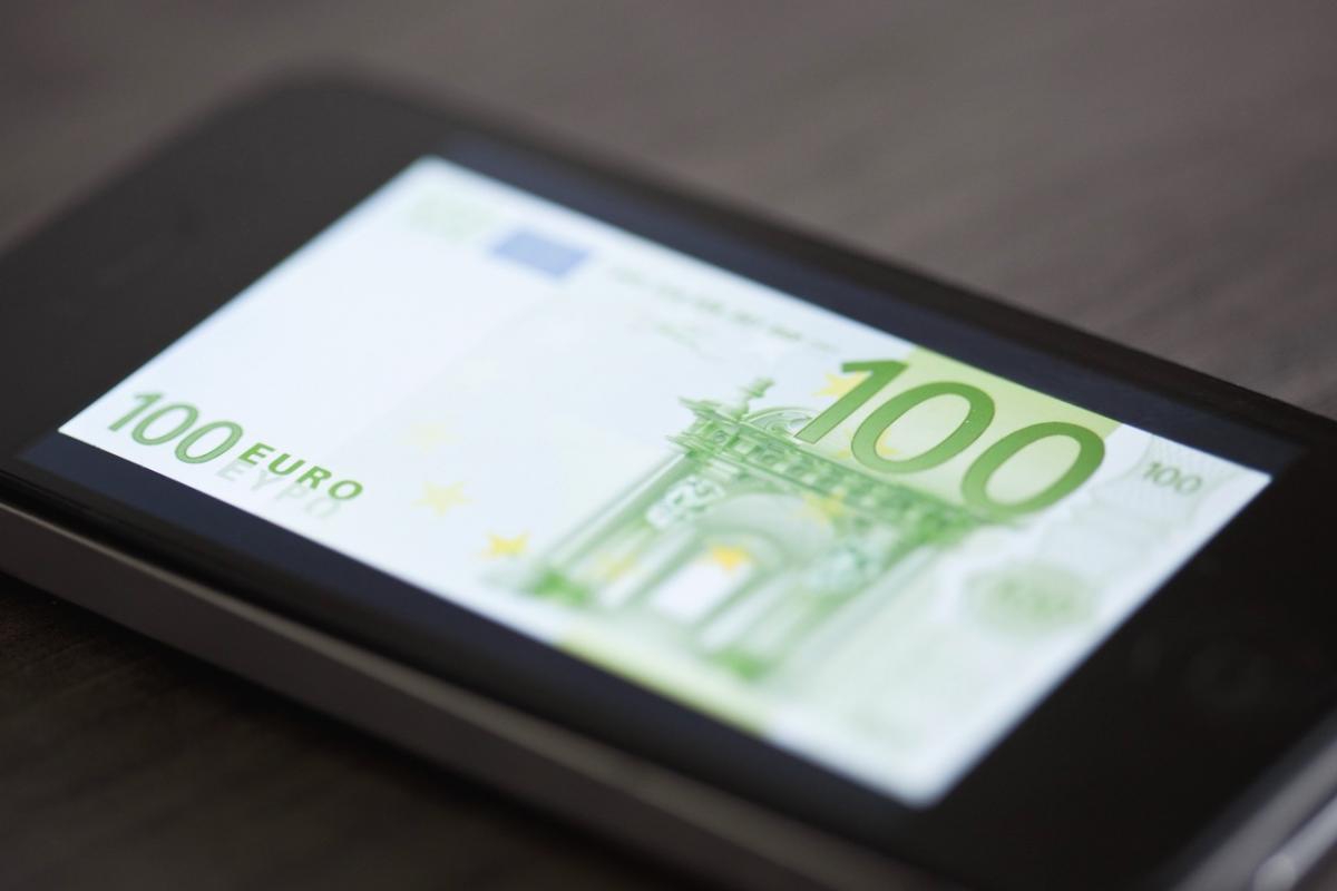 Billete de 100 euros en la pantalla de un smartphone para detectar falsificaciones.