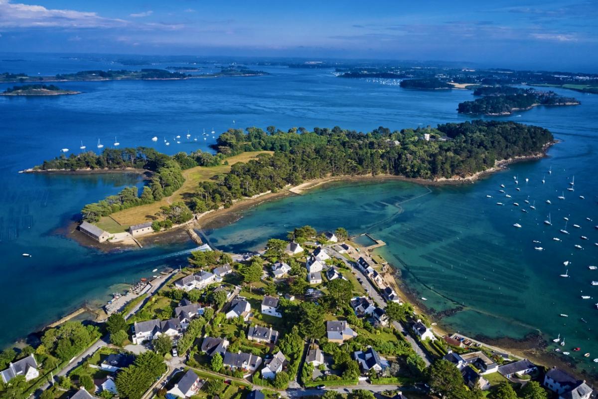 Isla privada en el golfo de Morbihan, Bretaña, rodeada de agua y barcos de recreo.