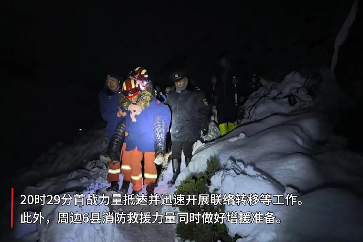 Rescatistas tibetanos trasladan a un excursionista entre la nieve durante la operación de evacuación nocturna en el valle de Gama, Tíbet.