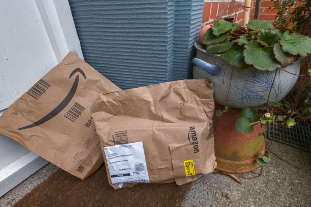Paquetes de Amazon apoyados frente a la puerta de una vivienda en Reino Unido.