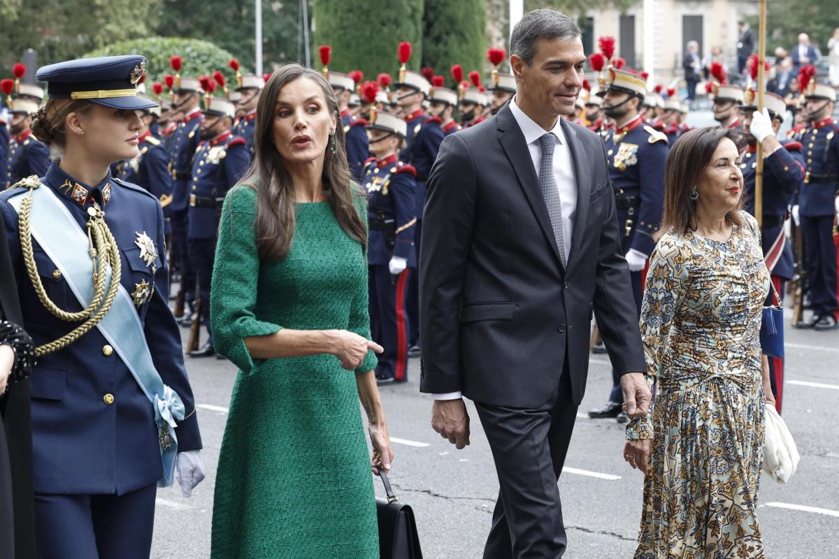 La reina Letizia conversa con la princesa Leonor junto al presidente del Gobierno, Pedro Sánchez, y la ministra de Defensa, Margarita Robles (dcha) a su llegada al desfile de las Fuerzas Armadas con motivo de la Fiesta Nacional este domingo en Madrid.