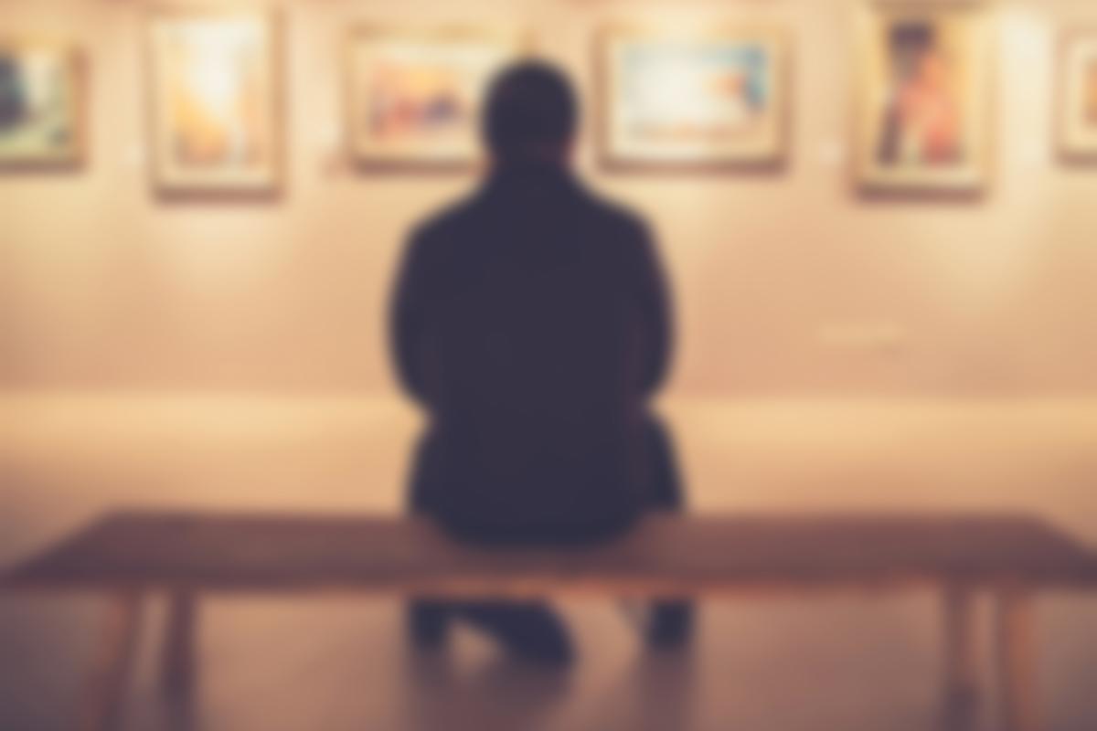 Imagen de recurso de un hombre en una exposición de cuadros en un museo.