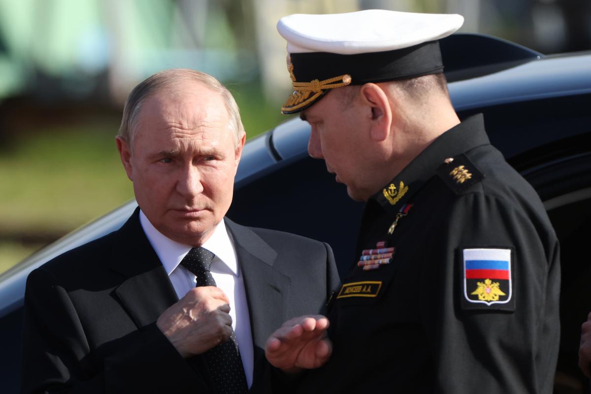 El presidente ruso Vladimir Putin (izquierda) escucha al comandante en jefe de la Armada rusa Alexander Moiseev (derecha).