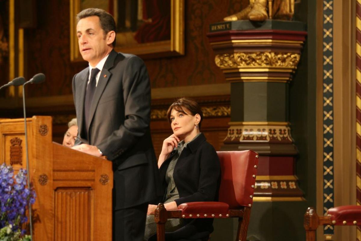 Carla Bruni-Sarkozy escucha a su esposo, el presidente francés, Nicolas Sarkozy, mientras pronuncia un discurso en el Palacio de Westminster en Londres, en 2008.