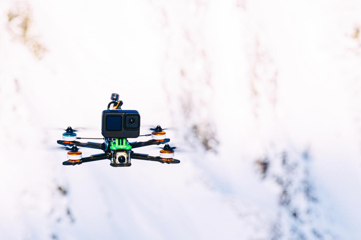 Dron con cámara de acción sobre un fondo de montañas nevadas.