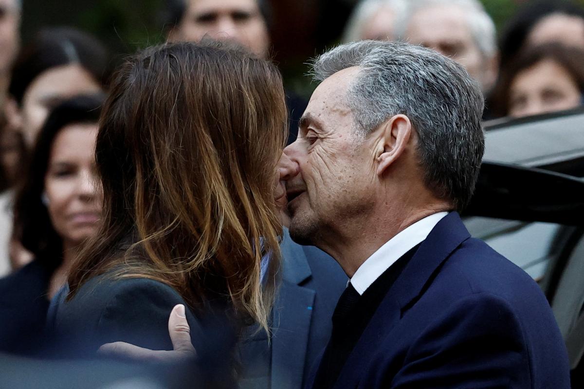 El expresidente francés Nicolas Sarkozy besa a su esposa, Carla Bruni, ante su casa de París.