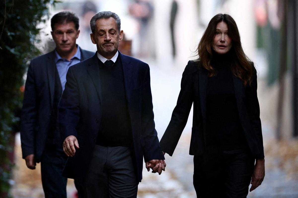 Nicolas Sarkozy y Carla Bruni salen de su casa de la mano, vestidos de negro, antes de que él se marche para entrar en prisión.