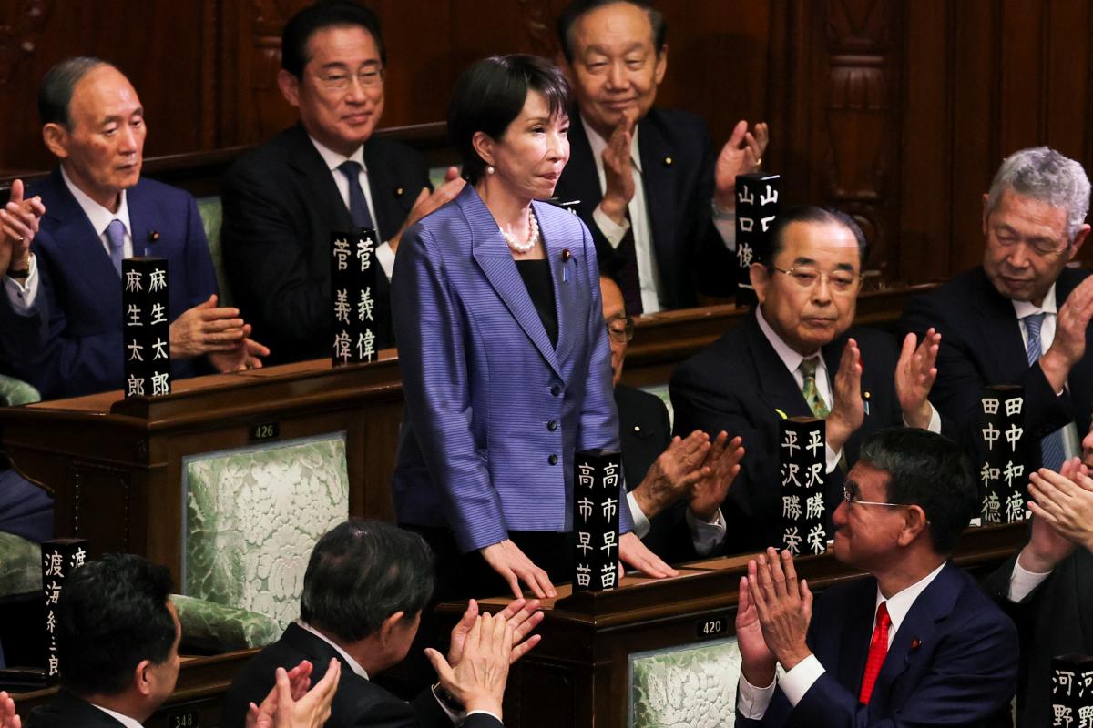 La nueva primera ministra de Japón, Sanae Takaichi, en pie, recibe aplausos en el Parlamento tras su elección.