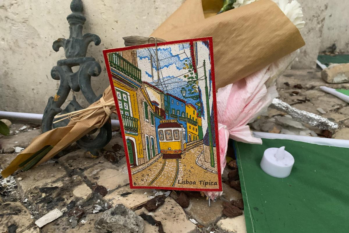Un dibujo del histórico tranvía lisboeta, colocado entre flores y velas en homenaje a las víctimas del accidente del Elevador da Glória.