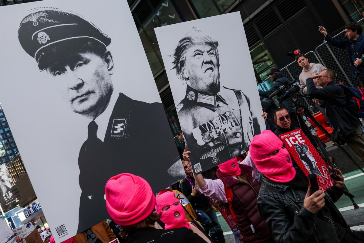 Carteles de burla de Donald Trump y Vladimir Putin en una manifestación en Nueva York.