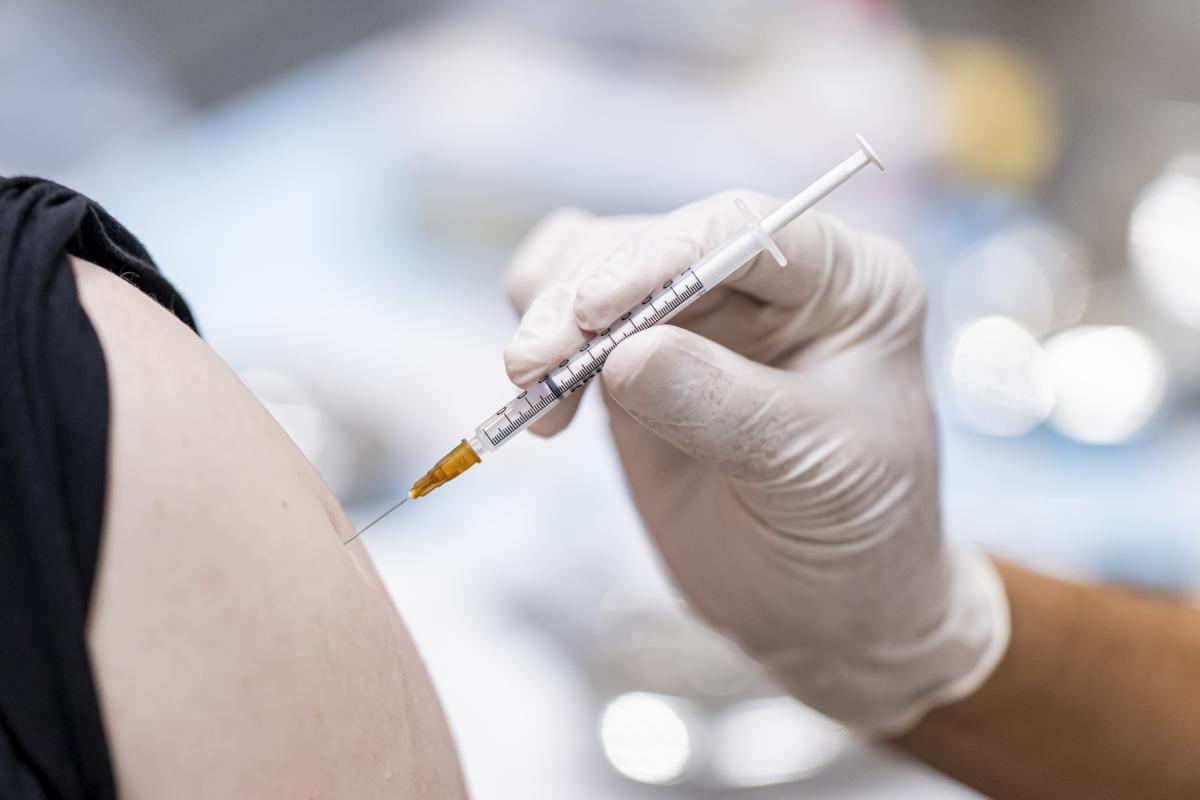 Un médico vacunando a una persona.