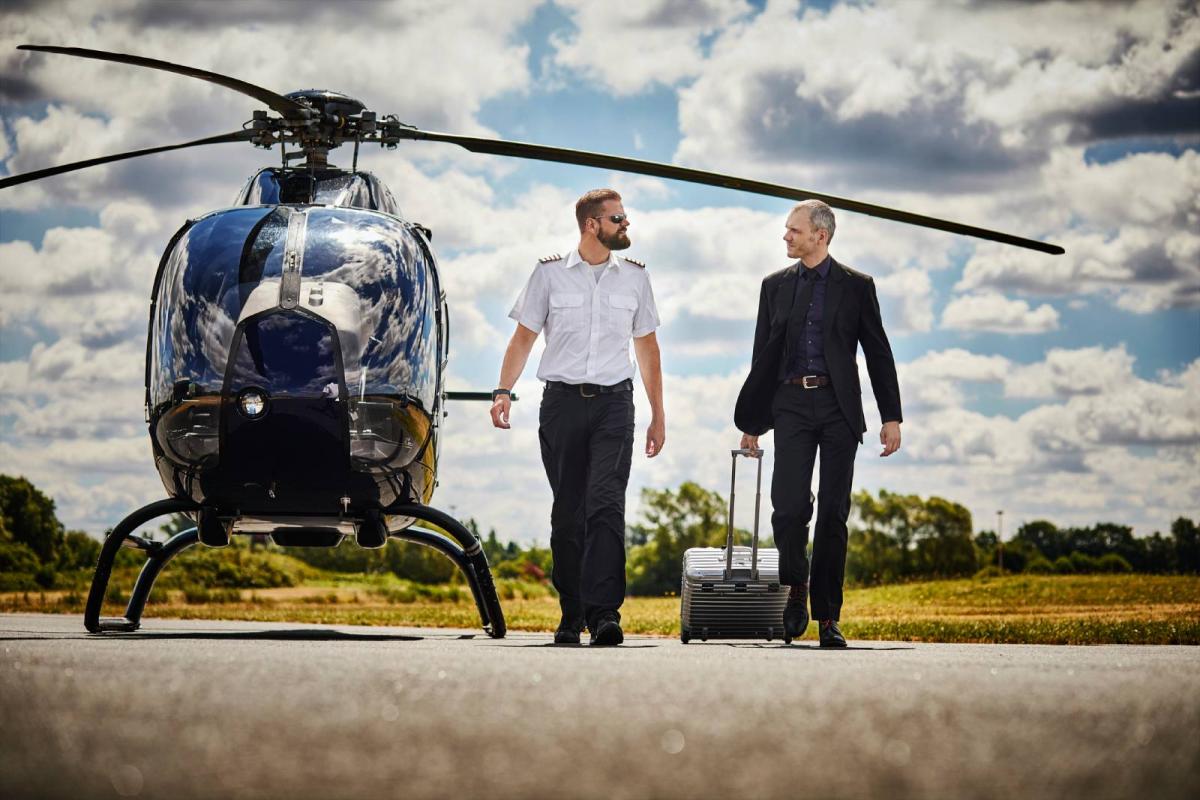 Un piloto acompañando a un hombre de negocios tras salir del helicóptero