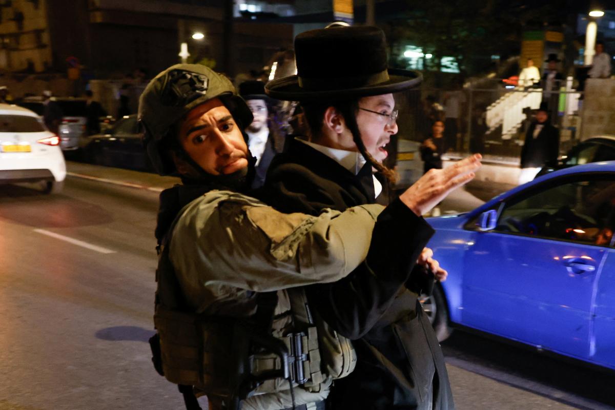 Un soldado israelí detiene a un manifestante ultraortodoxo en una protesta en Jerusalén para reclamar que se legisle la exención militar obligatoria a este colectivo.