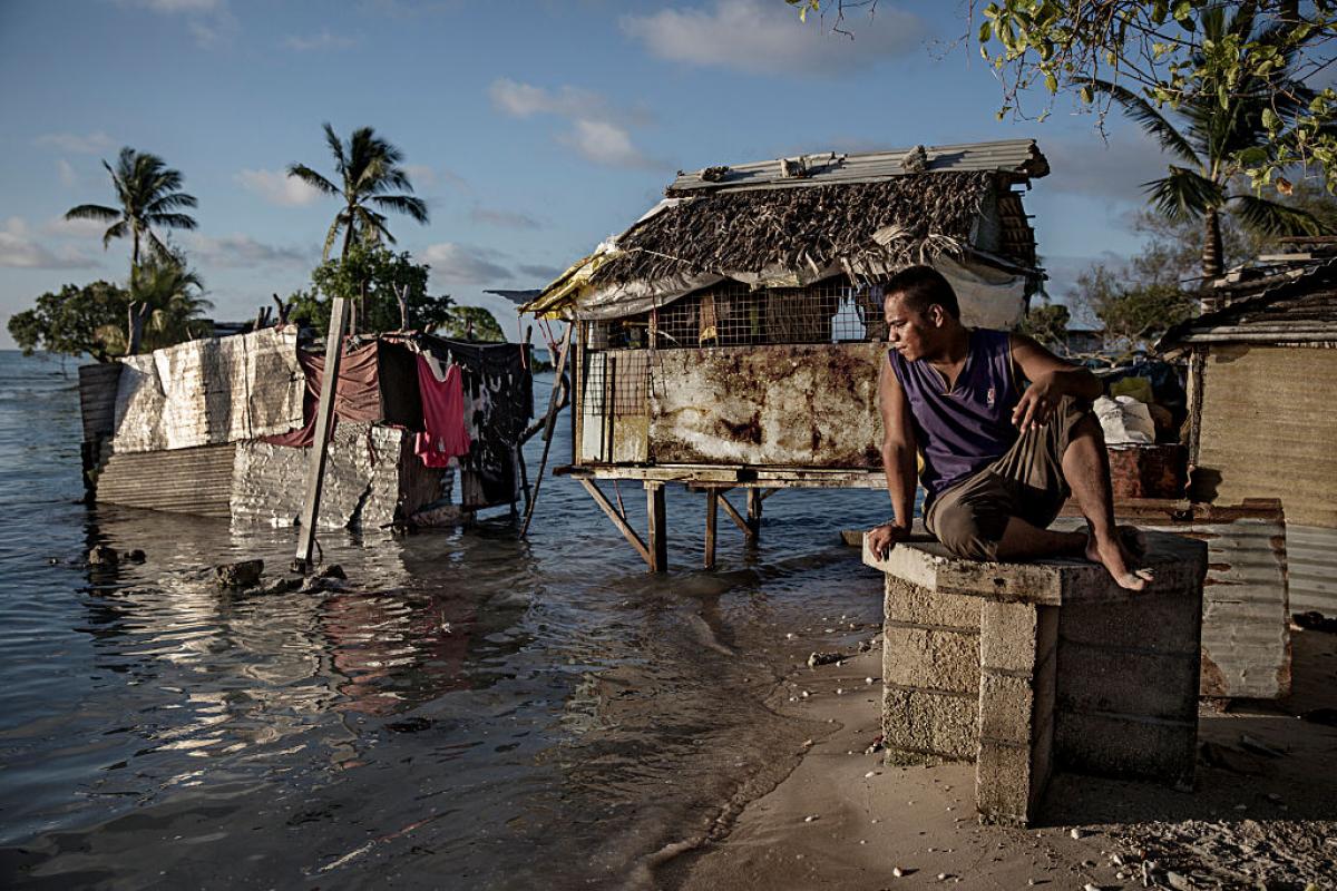 Un vecino del pueblo de Eita (Kiribati), sentado mientras mira cómo el agua del océano inunda lentamente su pueblo, en septiembre de 2015.
