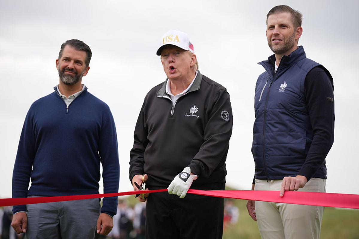 Donald Trump habla a sus hijos Donald Jr y a Eric Trump durante la inauguración de un nuevo campo de golf de la familia.