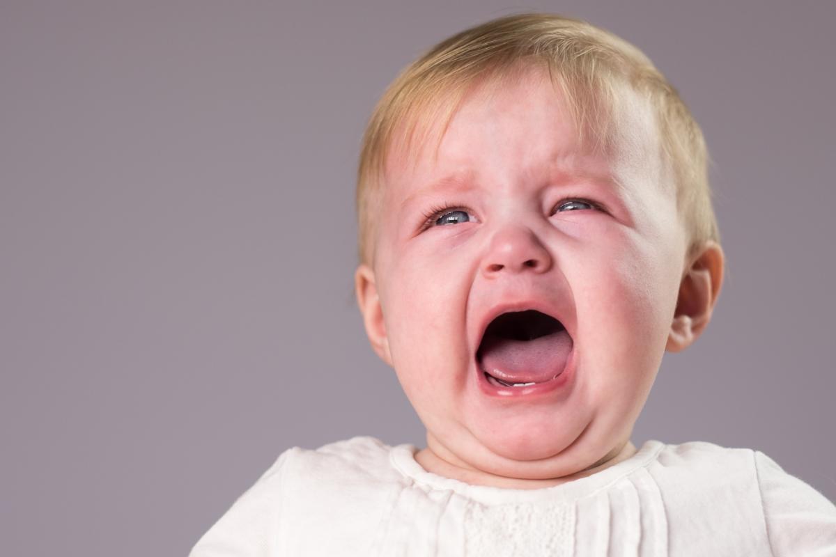 Un bebe rubio, llorando con la cara roja