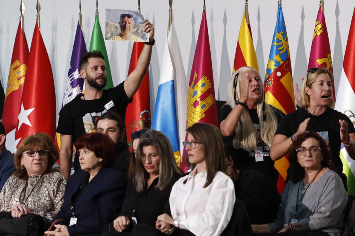 Varios de los familiares de las 237 víctimas de la dana muestran fotografías de los seres queridos fallecidos