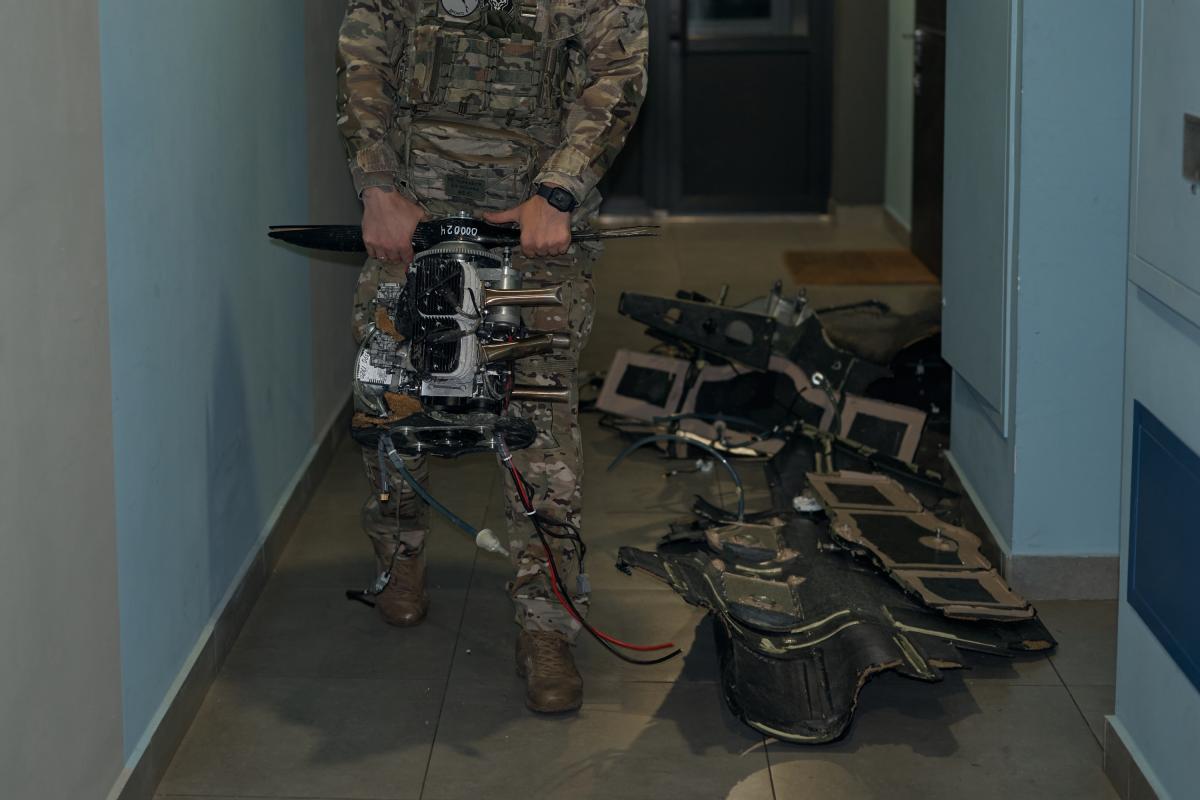 Los servicios de emergencia y la policía ucranianos inspeccionan un dron ruso Shahed-136 que no llegó a detonar dentro de un apartamento civil y retiran cuidadosamente sus fragmentos del edificio tras el ataque nocturno.