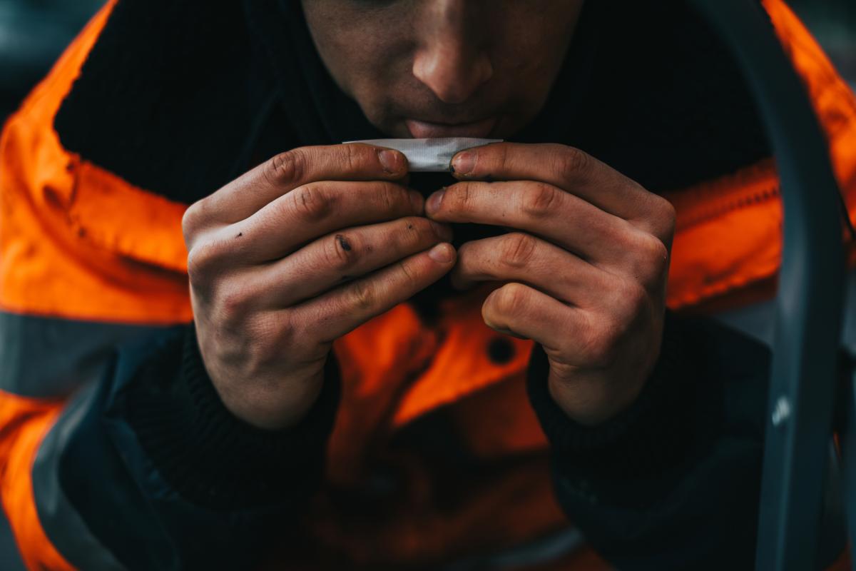 Un trabajador se lía un cigarro