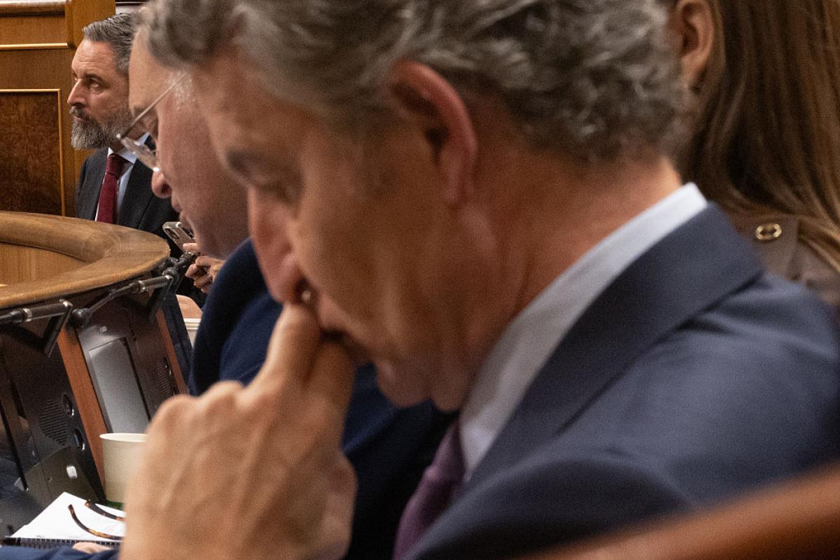 Núñez Feijóo, pensativo, con Abascal al fondo