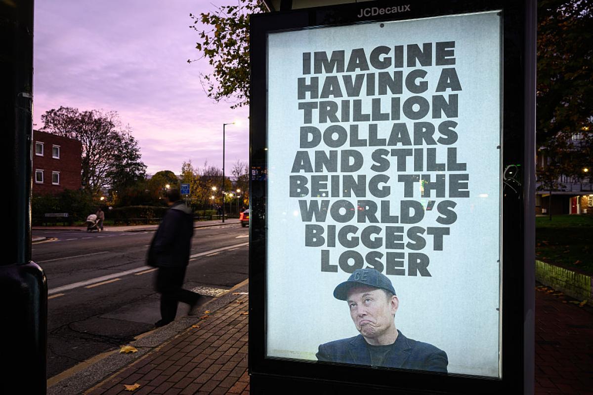 Cartel callejero con una imagen de Elon Musk y el mensaje “Imagine having a trillion dollars and still being the world’s biggest loser”.