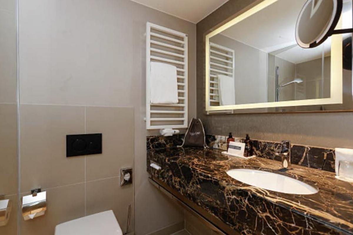 El baño de una habitación de hotel con sus productos de higiene colocados en fila