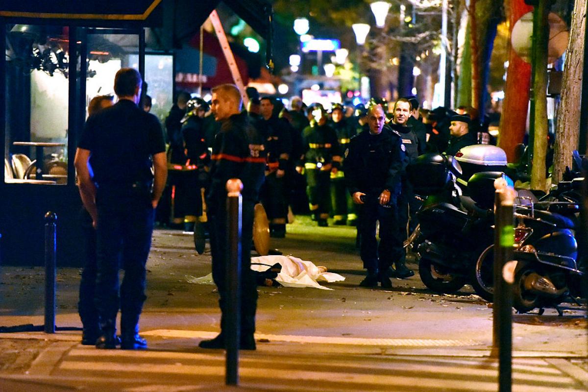 Agentes de policía, ante el cuerpo tapado de una víctima, a las puertas de la sala Bataclan, el 13 de noviembre de 2015, en París.