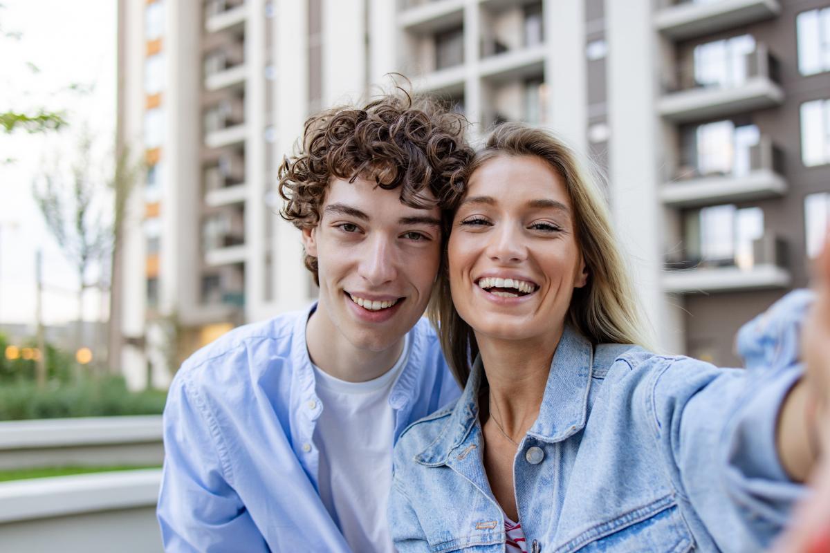 Una pareja sonriente tirándose un selfie.
