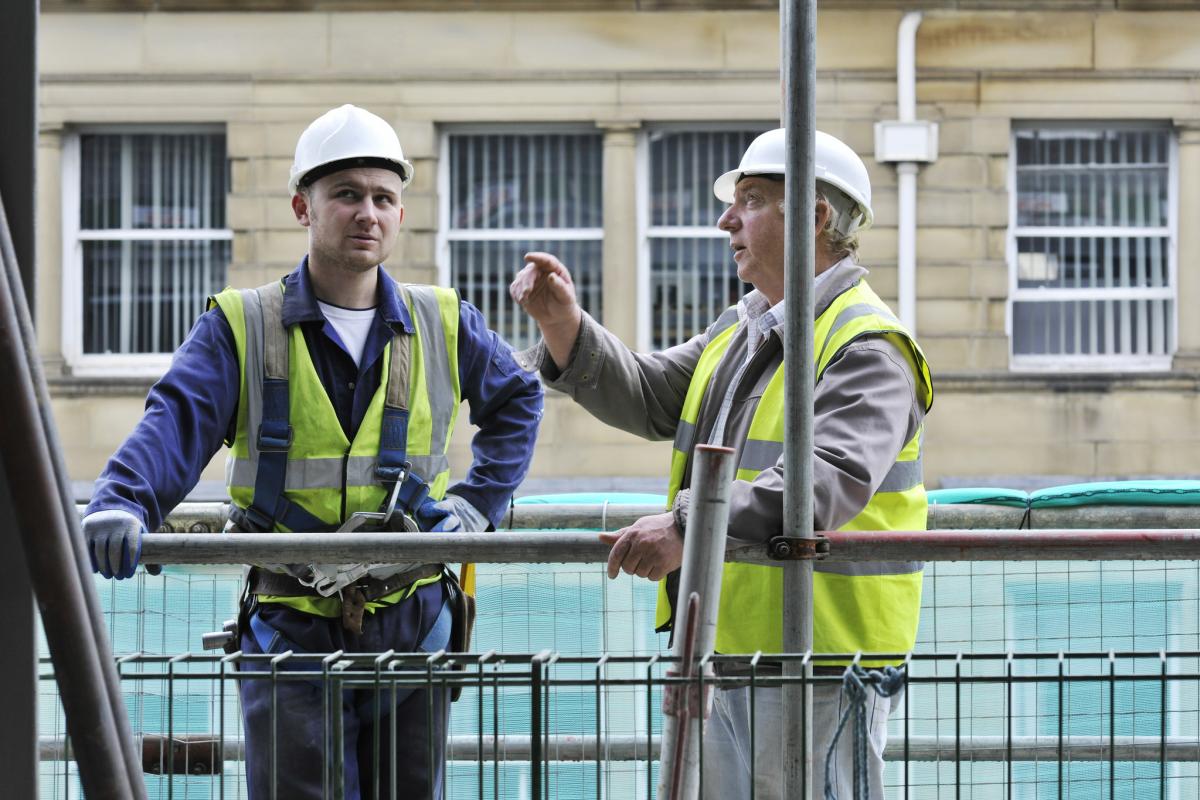 Trabajadores de la construcción hablando sobre la obra
