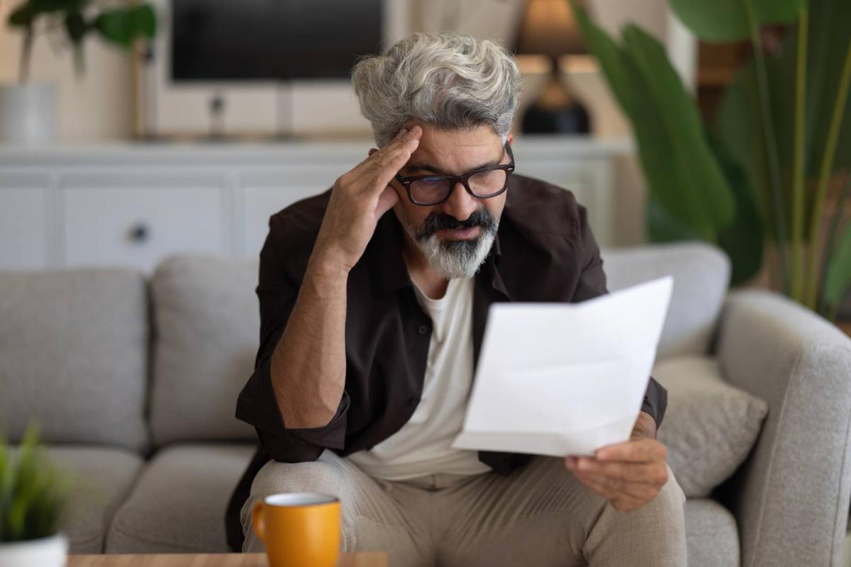 Hombre molesto mientras lee la notificación que acaba de recibir