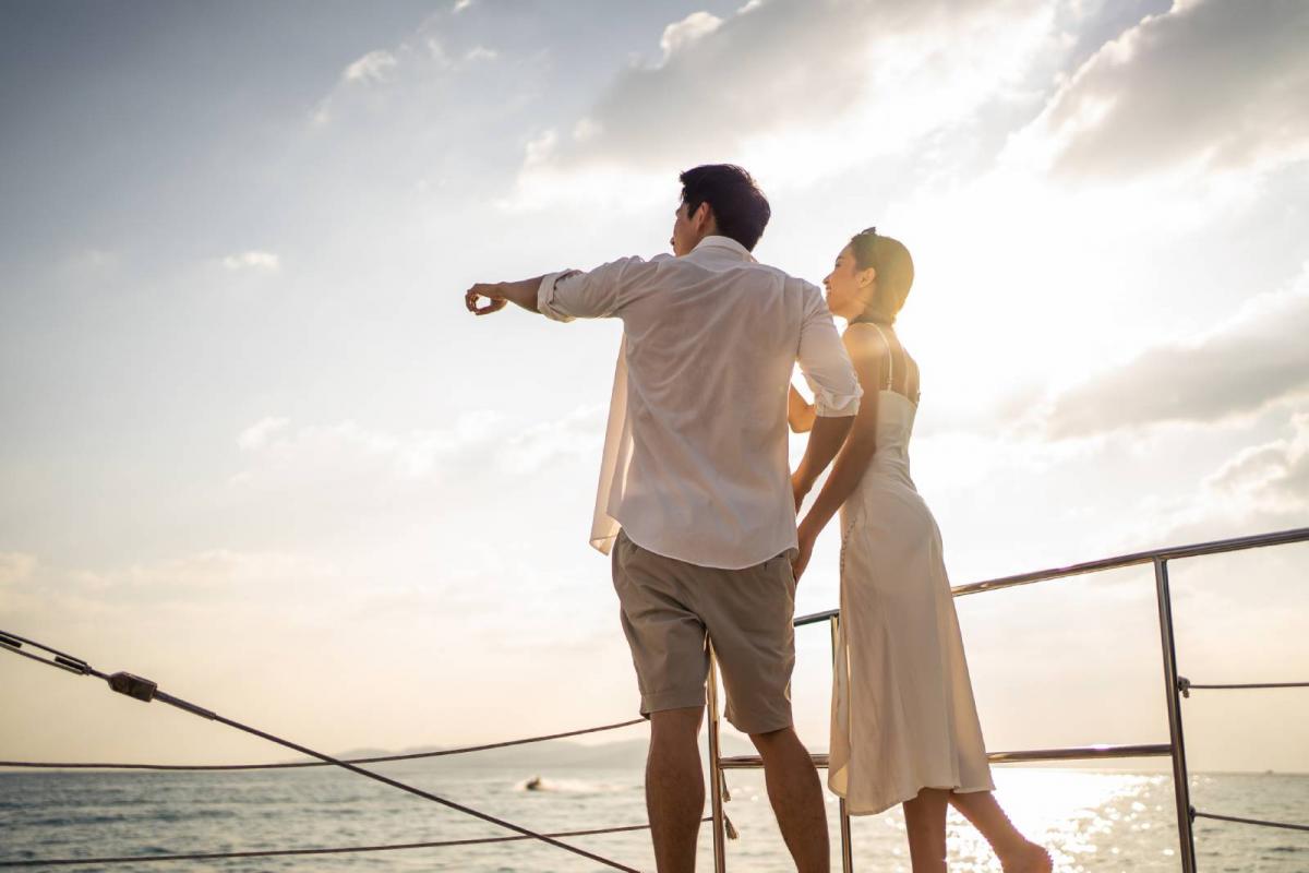 Pareja bebiendo champán mientras se va de fiesta en yate