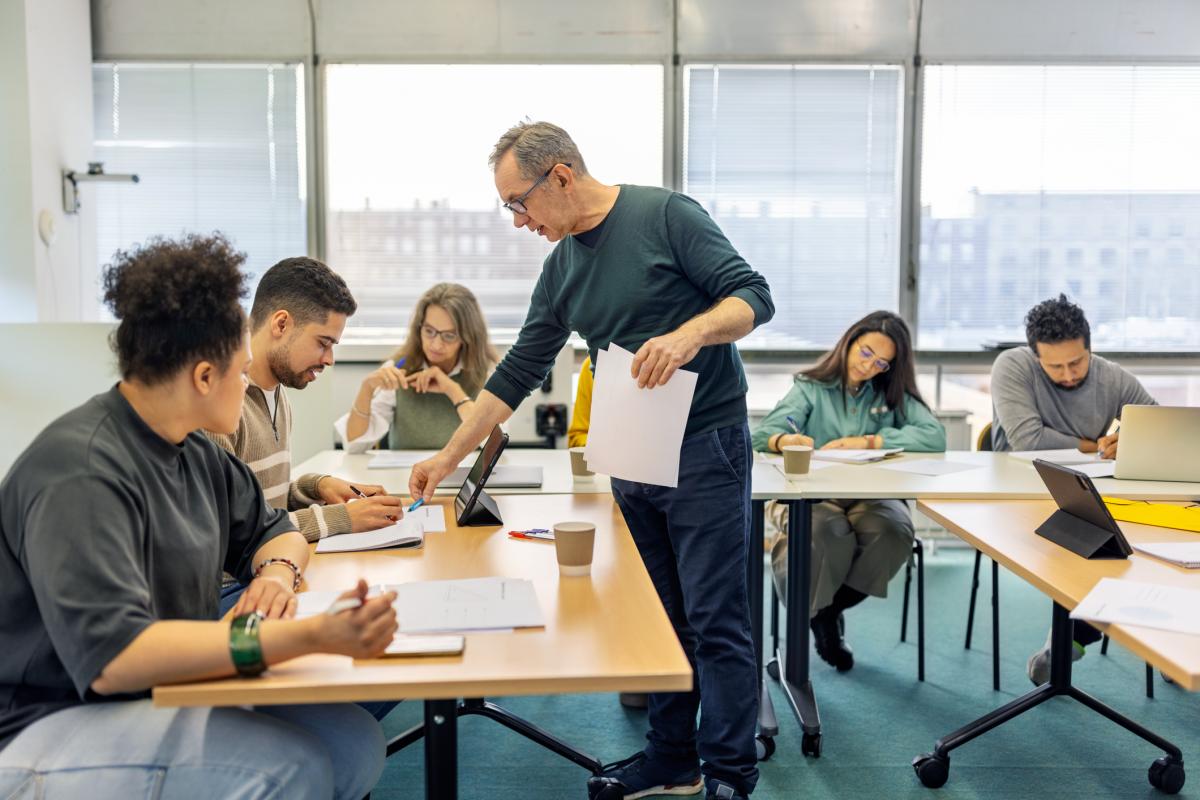 Un profesor dando clase a sus alumnos en el aula.