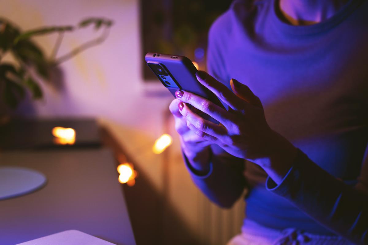 Imagen de archivo de una persona con un móvil y un ordenador.