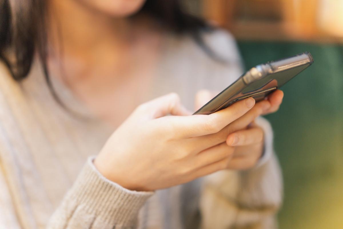 Una mujer usando la IA en su teléfono móvil.
