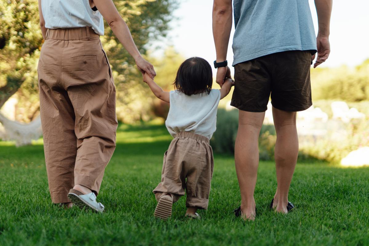 Foto de archivo de unos padres con su hija, en el parque.