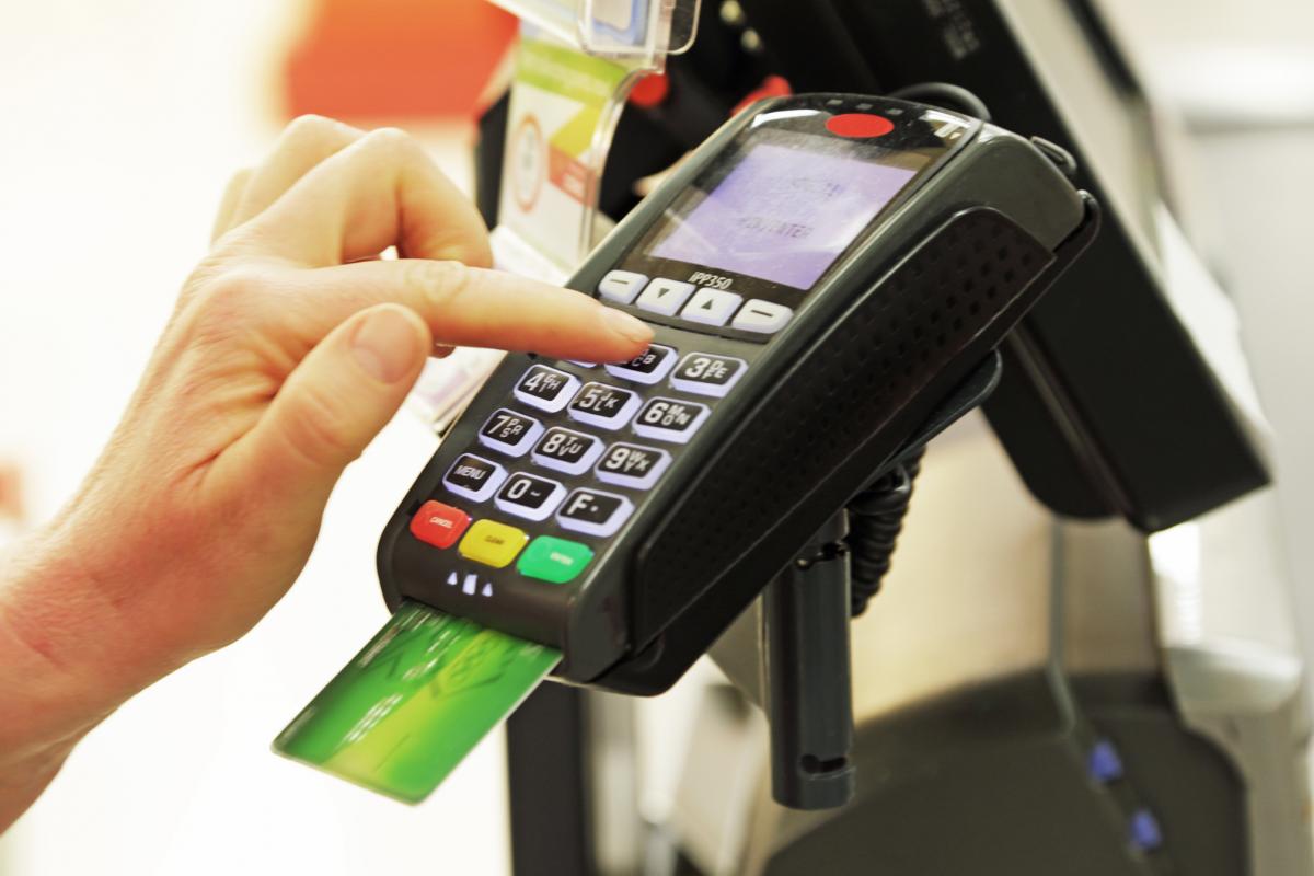 Persona ingresando su número PIN en una máquina de tarjetas