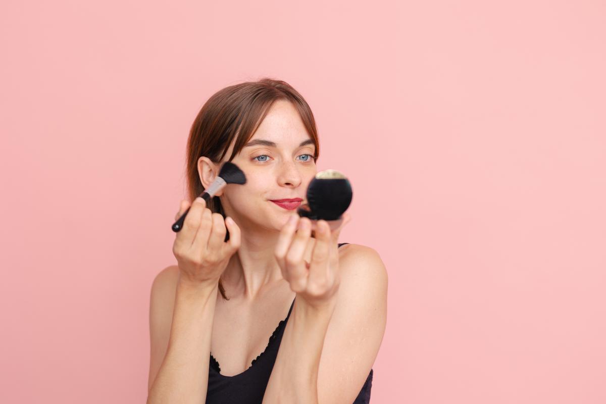 Una mujer aplicándose colorete