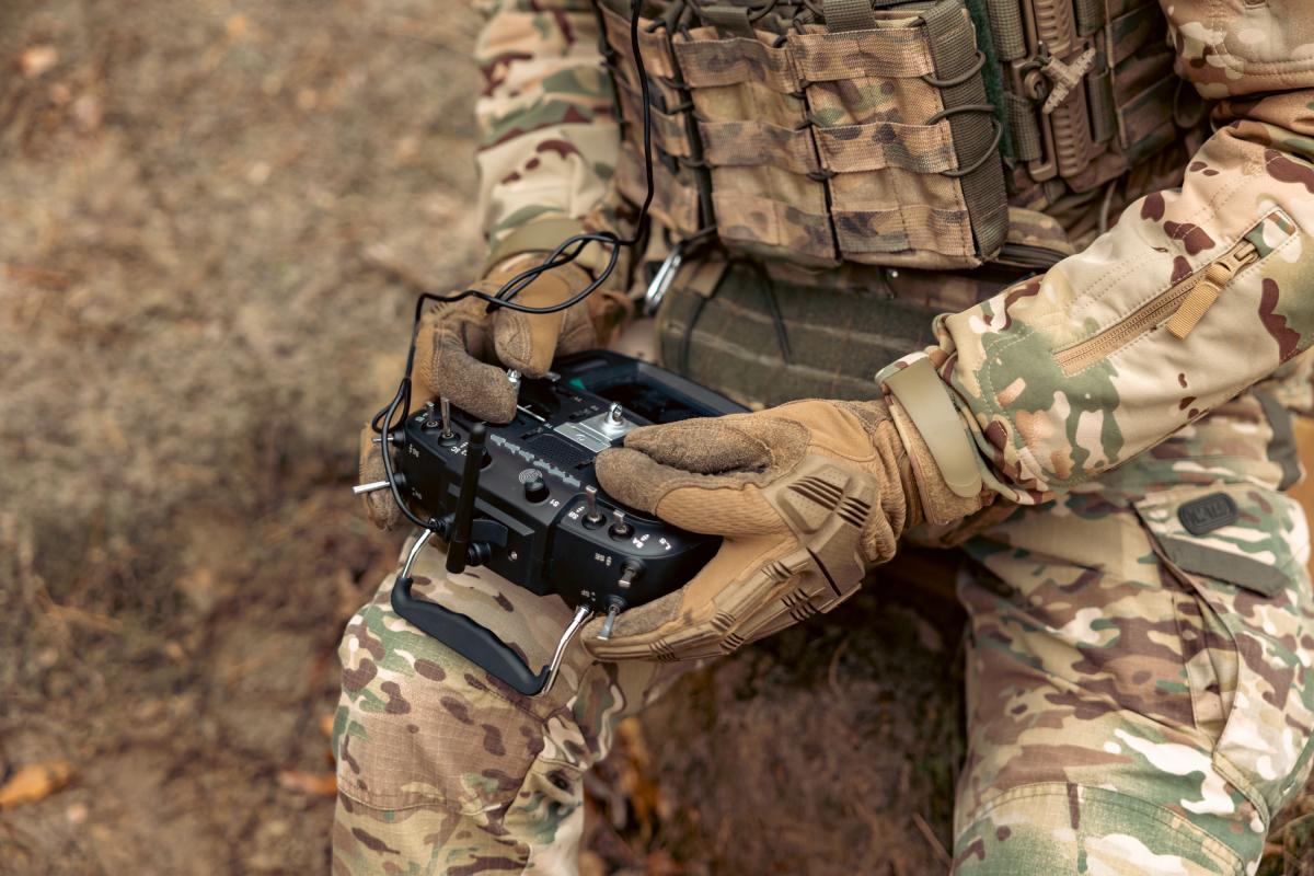 Un militar sentado, manipulando un control de dron.