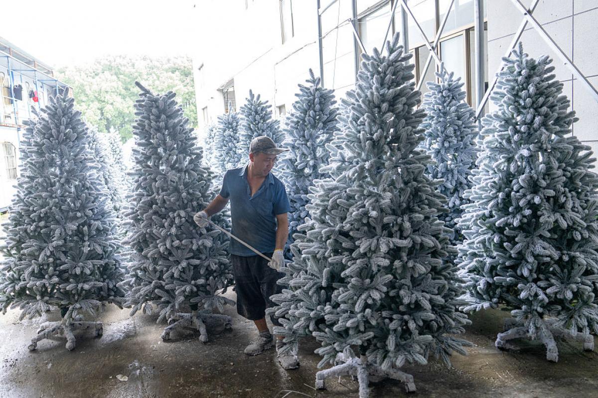 JINHUA, CHINA - 25 DE JUNIO: Un empleado trabaja en la línea de producción de árboles de Navidad en el taller de una empresa artesanal el 25 de junio de 2025 en JInhua, provincia de Zhejiang, China. Los empleados comenzaron a fabricar productos navideños a principios del verano para satisfacer la demanda del mercado internacional. (Foto de Yang Meiqing/VCG vía Getty Images)