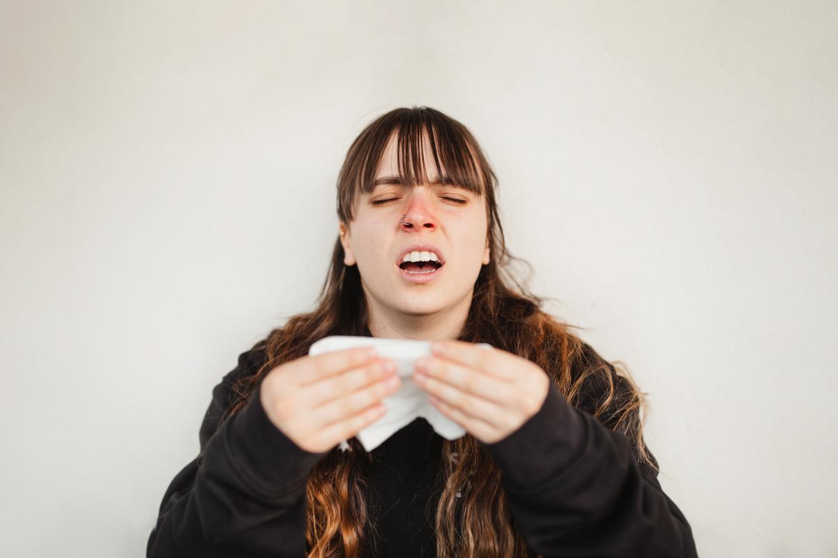 Una mujer, a punto de estornudar