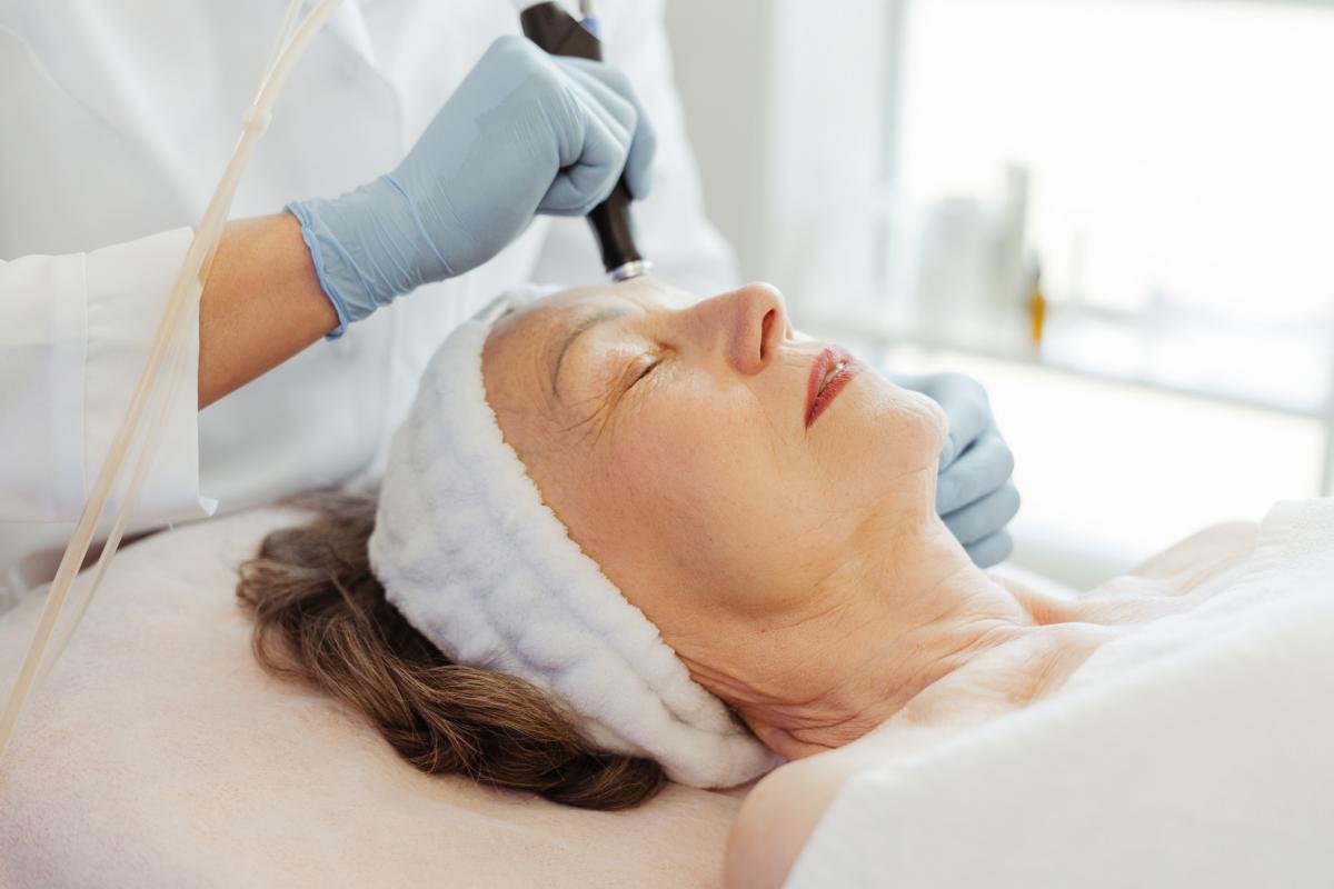 Una mujer en cabina haciéndose un tratamiento facial