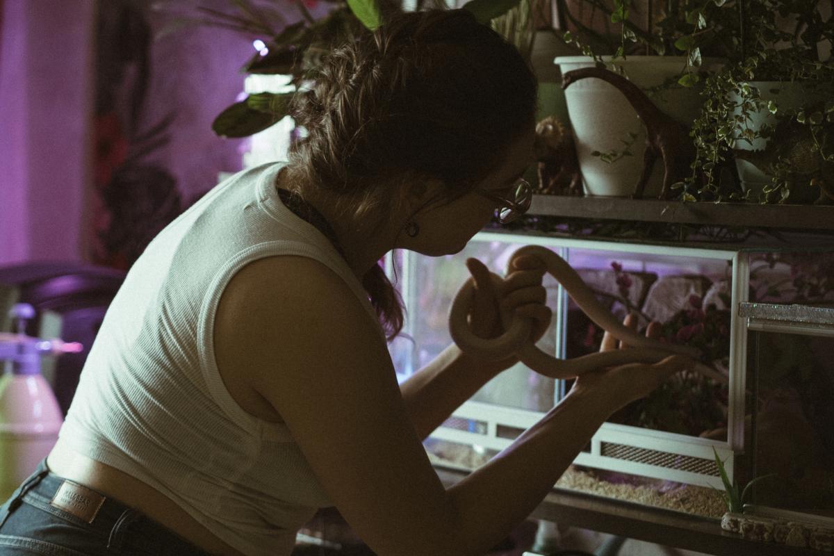 Una mujer juega con serpientes