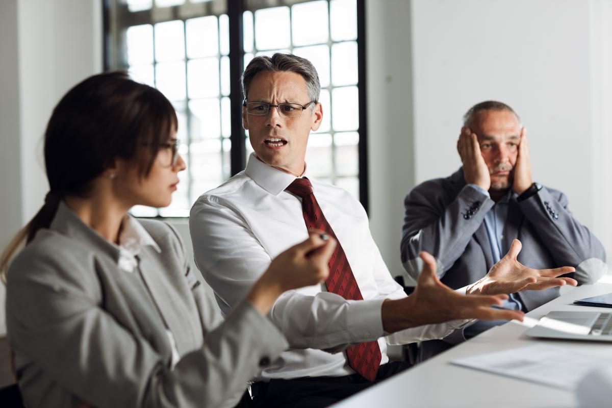 Tres trabajadores en la oficina del jefe