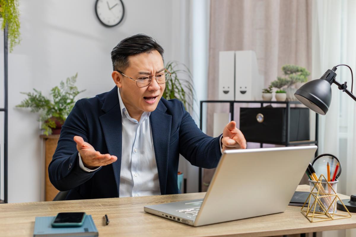 Un jefe enfadado hablando por el ordenador con un empleado