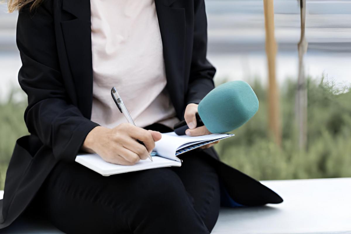 Una periodista anotando cosas en su cuaderno